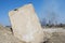 Concrete slab stuck in the ground against the background of a Smoking electrical substation. Background