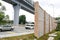 Concrete sound barrier wall next to busy highway rail track