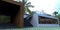 Concrete staircase to the roof terrace of a luxury country house. Stylish porch finished with a facade board. Palm tree in the