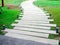 Concrete walkway with modern design pattern with garden lights on green grass