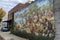 a concrete wall with a mural painted on it, depicting a fantasy or historical scene