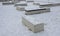 concrete white park bench block shape on snowy square clean smooth concrete
