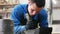 Concrete workshop - man is cleaning black concrete pouring mold with a spatula