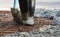 Concreting view of mans legs gum boots on a shovel