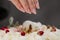 The condater sprinkles the cake with grated almonds and coconut. Close-up of a hand and pouring crumbs.