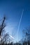 Condensation trace highlighted by the setting sun behind a twin-engine turbojet passenger plane in the March sky.