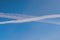 Condensation trails of planes in the sky. Sunny autumn blue sky. Aviation. Travel concept