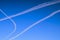 Condensation trails of planes in the sky. Sunny autumn blue sky. Aviation. Travel concept