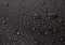 Condensation water drops on black glass background. Rain droplets with on dark surface. Abstract wet texture