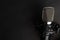 Condenser black studio microphone on a black background. Streamer, podcasts, music background