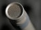 Condenser microphone in music and sound recording studio, gray background, close up.