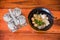 Condiment bottles near delicious spicy noodles put on a black cup on a wooden table