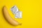 Condoms with banana and space for text on yellow background. Safe sex