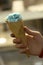 Cone blue icecream in kids hand close up photo