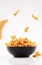 Cone corn chips in black bowl on white background