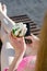 Cone with ice cream in hand of the girl in a bathing suit, smart phone in the other hand