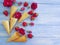 Cone wafflefor ice cream, fruit strawberry, dessert refreshment pattern creative rose flower pattern on a blue wooden