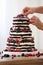 Confectioner decorates rustic naked wedding cake