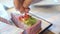 Confectioner hands decorate colored cheesecake with kiwi and strawberries