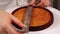 Confectioner measures tart foundation with metal ruler