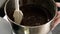 A confectioner mixing chocolate cream in a bowl