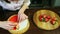 Confectioner puts half of ripe red strawberry on round colorful glazed cheesecake