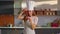 Confectioner putting cherry on cake at kitchen. Woman smiling at camera