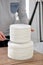 Confectioner stacking layers of white naked wedding torte cake