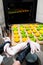 Confectioner takes out a baking sheet with round green and yellow eclairs from the oven