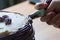 Confectioner using the pastry nozzle to finish the cake. Main light from behind.