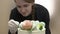 Confectioner woman decorates cake with flowers and macaroons for holiday.