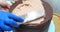 Confectioner woman is smearing cream on sides of cake using spatula, closeup view. culinary, baking and cooking food