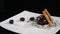 Confectioner at work in restaurant. Close-up. Cook serving delicious dessert in kitchen with black background