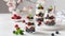 Confectionery banner. Sweet summer berry dessert. Trifle with cream cheese, raspberry and blueberry served in jars on white