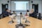 Conference microphones on the table over blurred of attendee in meeting room background