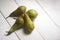 Conference pears green and fresh on a white wooden rustic geometric background with water drops