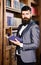 Confidence, success, education, research, literature concept. Professor holds book in vintage library. Bearded man in