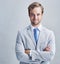 Confidence is always a winner. Studio shot of a businessman in a grey suit posing against a grey background.