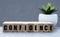 CONFIDENCE - word on wooden cubes on a gray background with a cactus