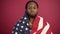 Confident African American man standing covered with United States flag