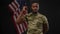 Confident African American soldier standing in camera flashes showing strength gesture and smiling looking at camera