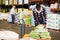 Confident African American warehouse worker loading sacks on trolley cart