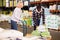 Confident African American warehouse worker with mature female assistant loading sacks with fertilizers on trolley cart