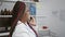 Confident african american woman scientist, smiling while engrossed in a hearty talk over her smartphone in the buzzing lab