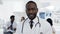 Confident african male doctor with team of cowoker on the background in hospital.