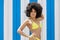 Confident afro american girl in yellow bikini holding hand on hi