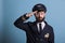 Confident airplane pilot saluting, wearing uniform