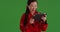 Confident asian woman interacting with portable tablet device on green screen