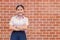 Confident Asian Woman Student  Arm Crossed uniform happy smile with brick wall copy space