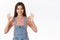 Confident, assertive good-looking woman in denim overalls, t-shirt, showing okay ok approval sign with smile, agree or